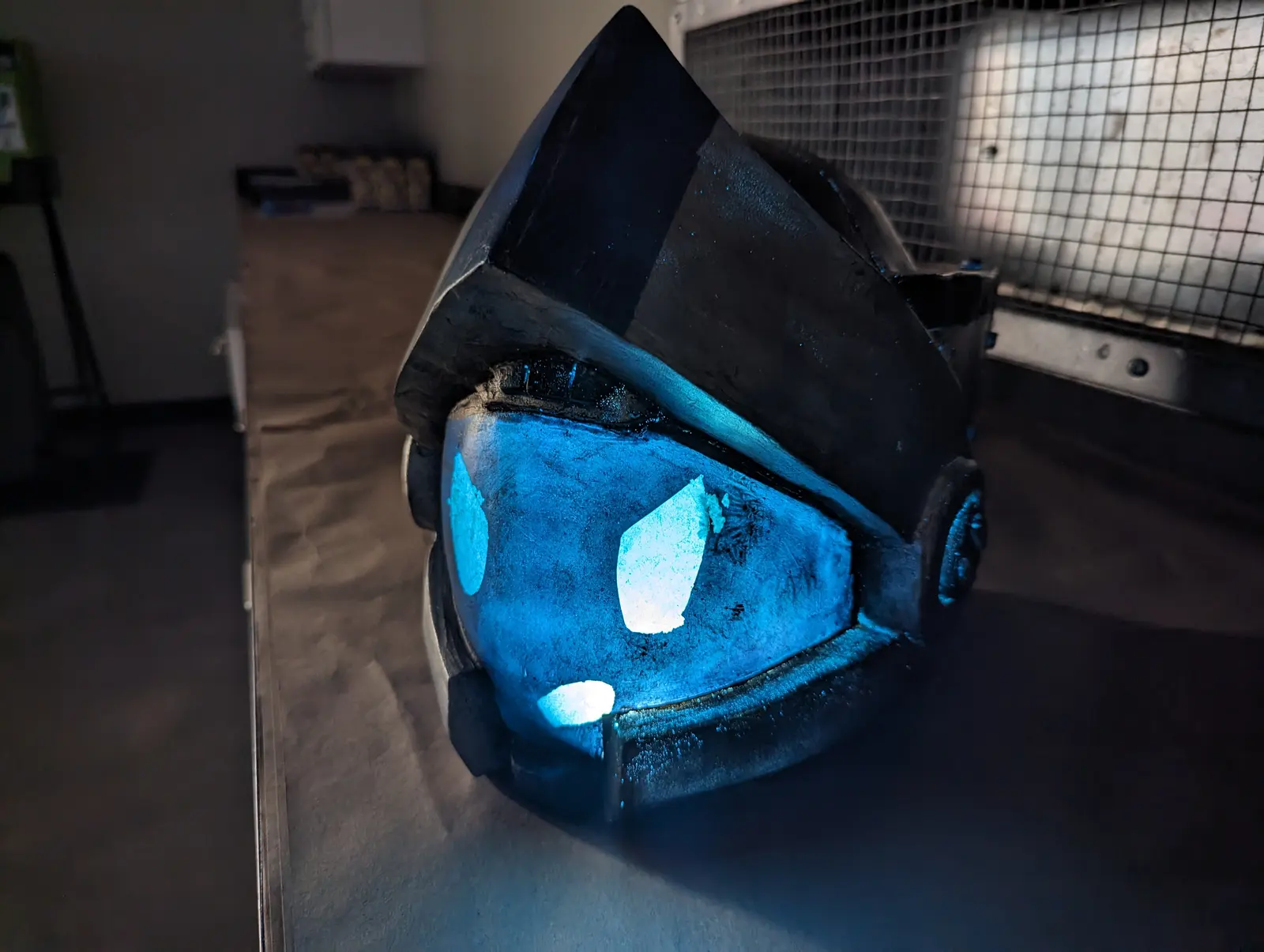 The finished Robitty helmet, its visor lit up blue